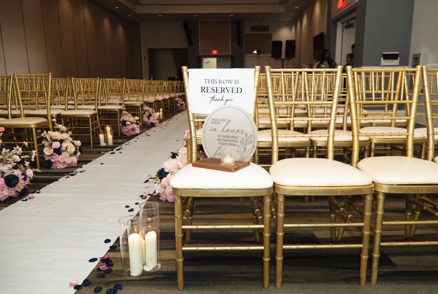 Reserved gold ceremony chairs with a thoughtful remembrance candle